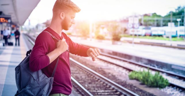 Mann am Bahnsteig wartet auf Zug