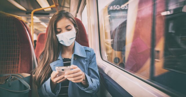 Junge Frau fährt mit Maske in der Bahn - Super Sparpreis Ticket