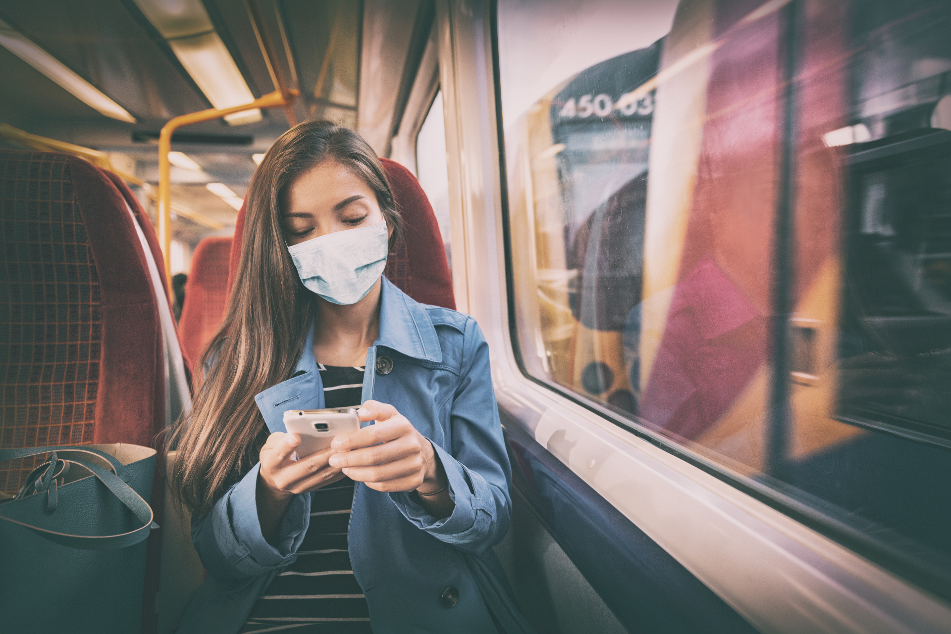 Junge Frau fährt mit Maske in der Bahn - Super Sparpreis Ticket