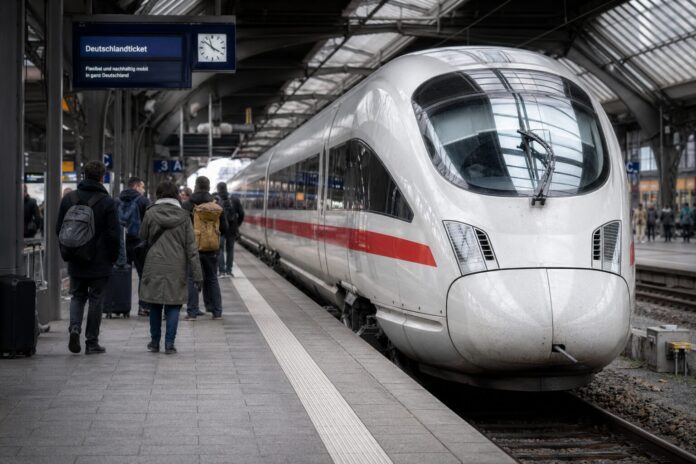 Reisende auf einem Bahnsteig mit ICE im Hintergrund als Symbolbild für Deutschlandticket und Fernverkehr